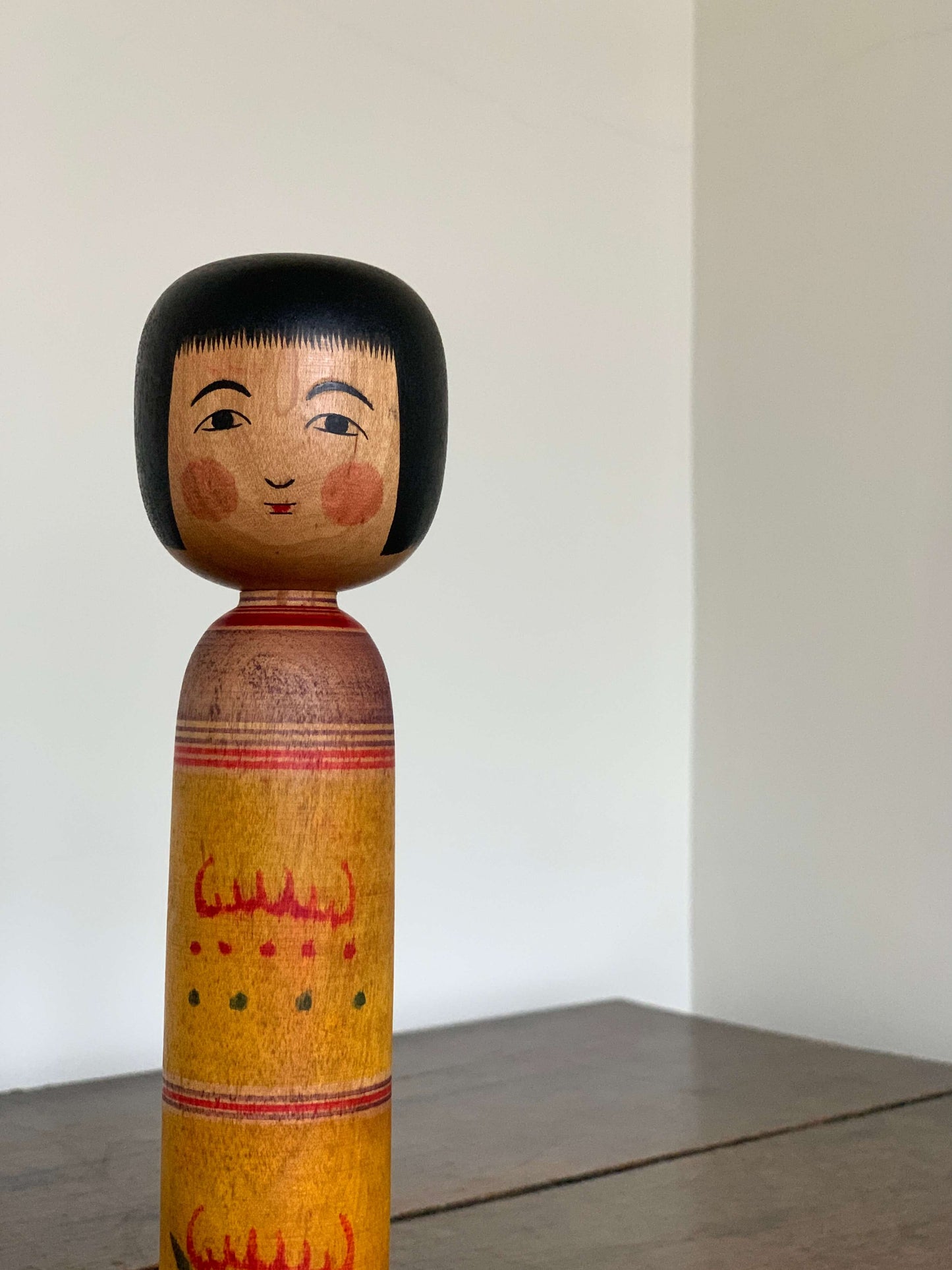 Vintage hand-painted Kokeshi doll with yellow design